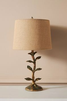 a lamp that is sitting on top of a table in front of a white wall