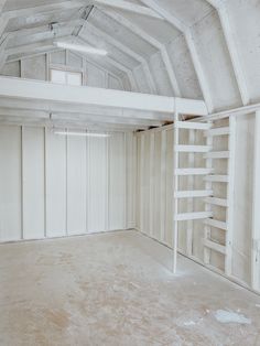 an empty room with white walls and ladders on the ceiling, is shown in this image