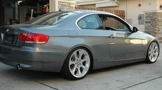 a silver car parked in front of a garage