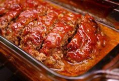 meatloaf in a glass casserole dish with sauce on top and slices cut out