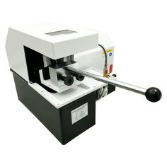 a machine that is sitting on top of a white surface with a black handle in front of it