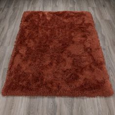 a red rug on the floor in a room with wood floors and hardwood floors,