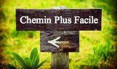 a wooden sign that says chemin plus facile in front of some grass