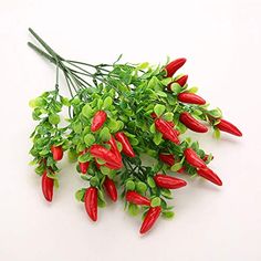 some red peppers and green leaves on a white surface