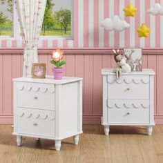 two white dressers sitting next to each other in a pink and white striped room