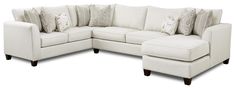 a white sectional couch with pillows on the top and bottom corner, sitting against a white background