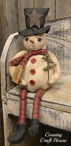 a stuffed snowman sitting on top of a bench