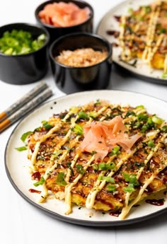 a plate topped with food next to bowls of rice and other dishes on a table