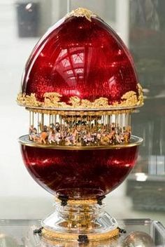 a red and gold object sitting on top of a glass table in front of a window