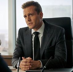 a man in a suit and tie sitting at a desk