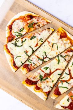 sliced pizza sitting on top of a wooden cutting board