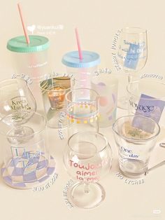 there are many different cups and glasses on the table with names written all over them