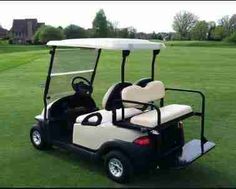 a white and black golf cart on the grass