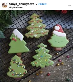 decorated christmas cookies sitting on top of a cooling rack