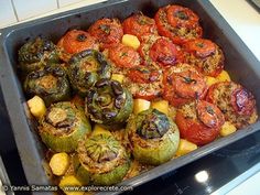 a pan filled with stuffed peppers and other vegetables on top of a stove burner