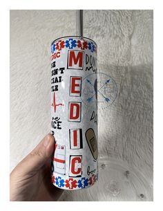 a hand is holding up a can shaped like an american flag with the words medic on it