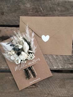 a wedding card with feathers and flowers on it next to an envelope that says will you be my bride?