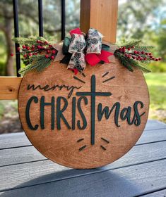 a merry christmas sign hanging from the side of a wooden porch chair on a deck