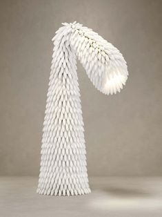 a white sculpture made out of toothpicks on top of a gray surface with light coming from it