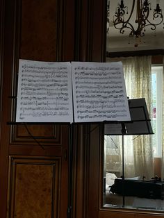 sheet music is hanging from a chandelier