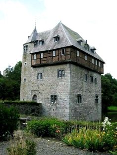 an old building with lots of windows next to flowers