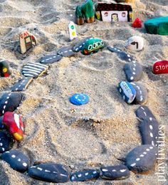 a toy car track in the sand with other toys