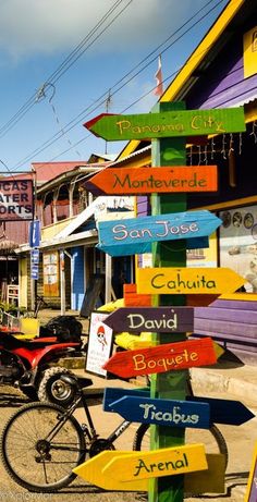 a bicycle parked in front of a colorful building with lots of signs on it's side