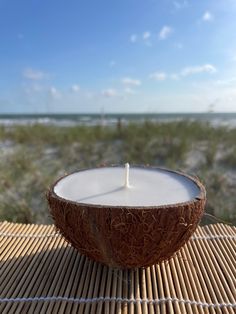 a white candle sitting inside of a coconut shell