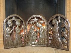 three metal figurines sitting next to each other on a tile floor in front of a fire place