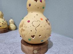 a ceramic vase sitting on top of a wooden stand next to other small figurines