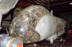 an old airplane is being worked on in a garage with other equipment around the space shuttle