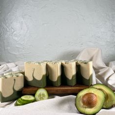 cucumber and avocado soaps on a wooden tray with white cloth