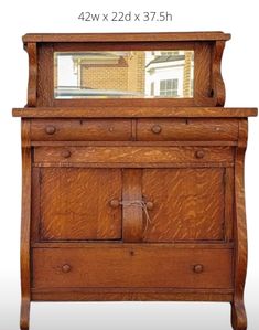 an old wooden dresser with a mirror on it's top and bottom drawer below