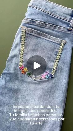 the back pocket of a pair of jeans with an embroidered chain on it and a message written in spanish