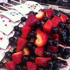 strawberries and blueberries are arranged on playing cards