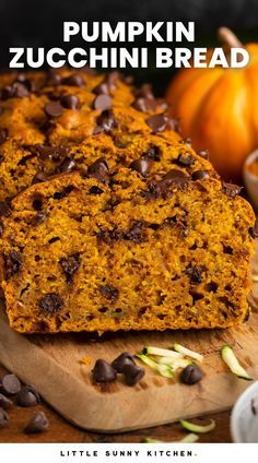 pumpkin zucchini bread on a cutting board with chocolate chips and pumpkins in the background