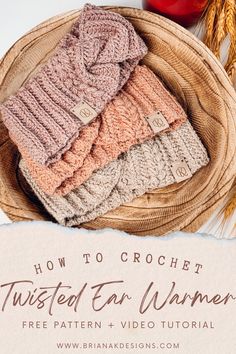 three knitted scarves sitting on top of a basket next to some wheat stalks