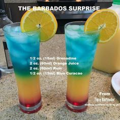 two tall glasses filled with blue and yellow liquid sitting on top of a counter next to each other