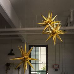 three golden stars hanging from the ceiling in an office