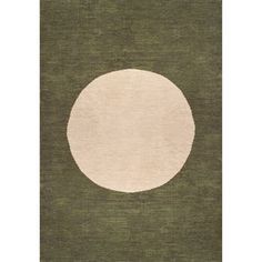 a green rug with a white circle in the center on top of an area rug