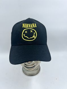 Get your hands on this officially licensed Nirvana snapback hat! The black hat features the iconic yellow smiley face logo embroidered on the front, making it the perfect addition to any grunge fan's collection. It's one size fits all and has an adjustable snapback closure for a comfortable fit. Wear it to your next concert or simply add it to your daily outfit for a touch of rock 'n' roll style. The hat is brand new and has never been worn, making it a great gift for yourself or any Nirvana enthusiast. Please look at pictures for condition and I do combine shipping on all items. Black Smiley Face, Smiley Face Logo, Yellow Smiley Face, Rock N Roll Style, Face Logo, Black Hat, Smiley Face, Hat Cap, Nirvana