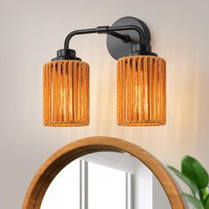 a bathroom with a mirror and lights on the wall next to a potted plant