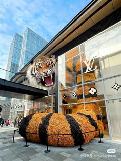 a large stuffed tiger sitting in front of a building