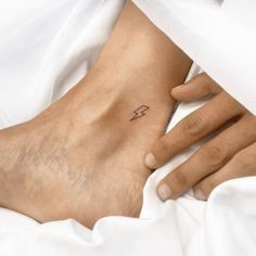 a woman's foot with a small tattoo on it