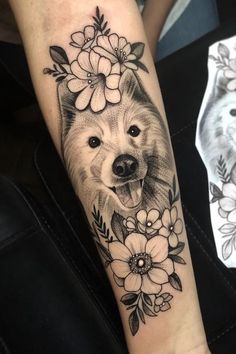 a black and white photo of a dog with flowers on it's arm