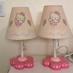 two pink hello kitty lamps on a table