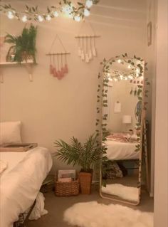 a bedroom with a bed, mirror and plants on the wall next to each other