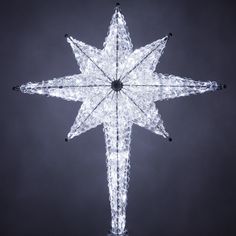 a lighted snowflake star ornament on a black background