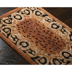 a brown and black rug on top of a wooden floor