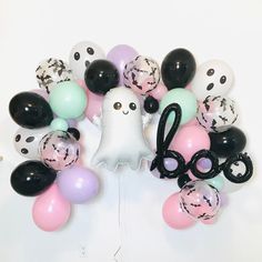 a bunch of balloons that are in the shape of a ghost and some black scissors